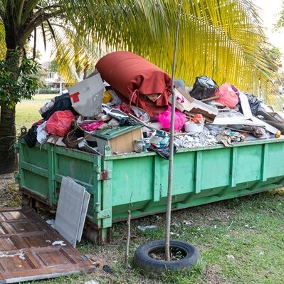 Removal rubbish dumpster bin with load of material for disposal from construction site